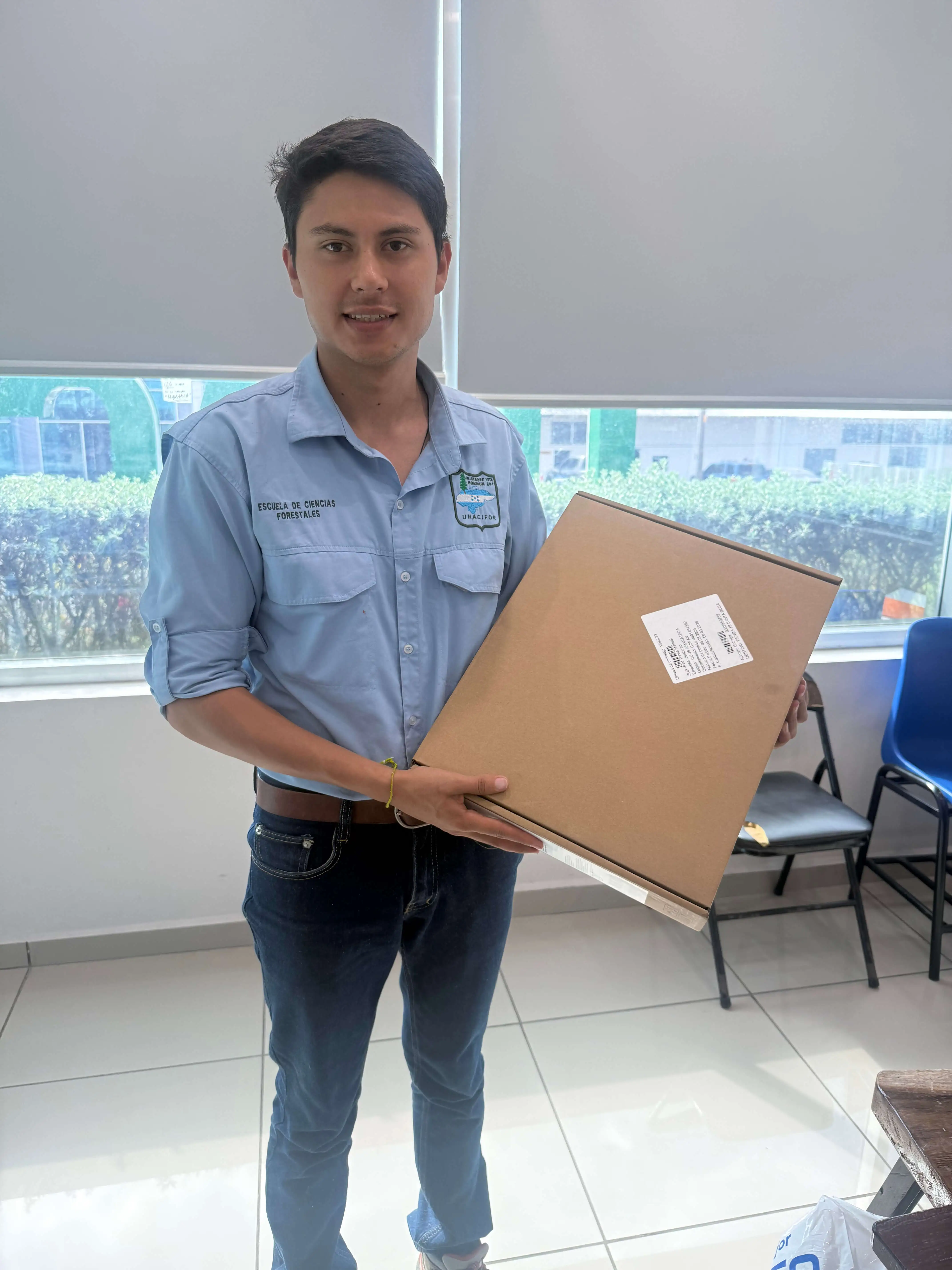 Becario de ASONOG recibiendo equipo